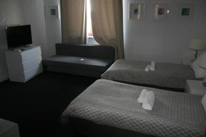 een hotelkamer met 2 bedden en een televisie bij Drukarnia Smaku in Oława