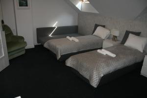 una camera d'albergo con due letti e un divano di Drukarnia Smaku a Oława