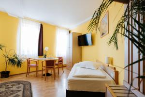 um quarto com uma cama, uma mesa e uma sala de jantar em Lázár Pension & Restaurant em Gheorgheni