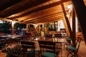 un patio con mesas y sillas en una terraza en Lázár Pension & Restaurant en Gheorgheni