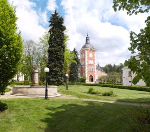 een groot gebouw van rode baksteen met een toren bij Hotel Berger in Kamenice nad Lipou