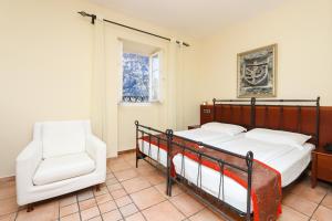 a bedroom with two beds and a chair at Hotel Splendido in Kotor