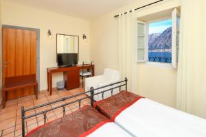 a bedroom with a bed and a desk and a television at Hotel Splendido in Kotor