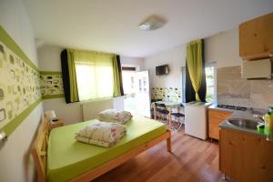 a small room with a green bed in a kitchen at Pensiunea Soare si Luna in Praid