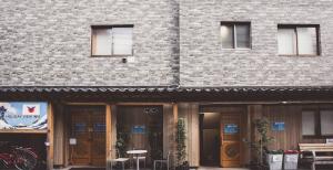 a brick building with doors and chairs in front of it at Holiday View Inn in Tokyo