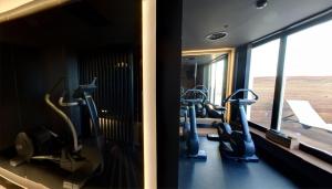 a gym with treadmills and ellipticals in front of a mirror at El Môderne Hotel in Gijón +37 photos