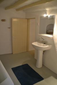 a bathroom with a white sink and a mirror at Kastro in Parikia