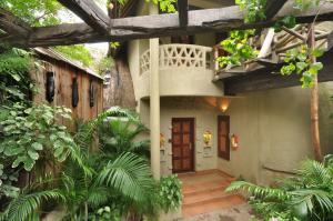 a house with a balcony on the side of it at Vedic Village Spa Resort Kolkata in Kolkata
