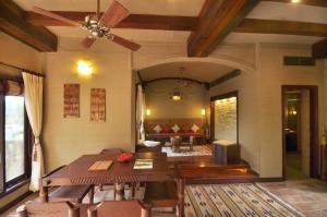 a living room with a ceiling fan and a table at Vedic Village Spa Resort Kolkata in Kolkata +61 photos