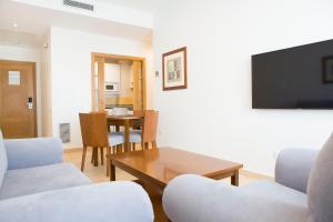 a living room with a tv and a table at Aparthotel Albufera in Alfafar