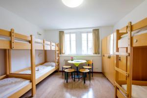 a room with a table and chairs and bunk beds at Jugendherberge Youth Hostel Rothenburg Ob Der Tauber in Rothenburg ob der Tauber