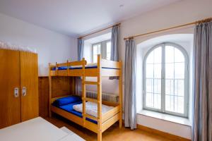 ローテンブルク・オプ・デア・タウバーにあるユーグントヘルベルゲ ユース ホステル ローテンブルク オプ デア タウバーのベッドルーム1室(二段ベッド2台、窓付)が備わります。