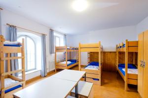 a room with four bunk beds and a table at Jugendherberge Youth Hostel Rothenburg Ob Der Tauber in Rothenburg ob der Tauber