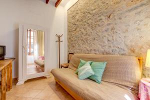 a living room with a couch and a stone wall at Casa Coll by Sealand Villas in Pollença