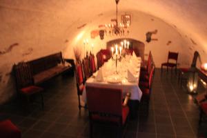uma sala de jantar com uma mesa longa e cadeiras vermelhas em Brunsbo G:a Biskopsgård Hotell & Konferens em Skara