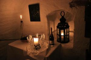 - une table avec une bougie et une bouteille de vin dans l'établissement Brunsbo G:a Biskopsgård Hotell & Konferens, à Skara
