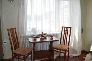 a table and two chairs in front of a window at Apartamenty na Prospekte Pobeda Revolutsii 99 in Shakhty