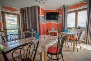 una sala da pranzo con tavoli, sedie e TV di La Casa Del Grillo 2 ad Aosta