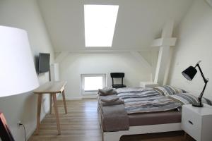 a bedroom with a bed and a desk and a window at Quartier36 in Schleswig