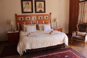 a bedroom with a bed with two pictures on the wall at Feathers Guest House in Middelburg