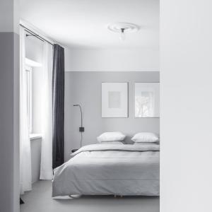 a white bedroom with a bed and a window at Minimalist. Apartment & Studio in Šiauliai