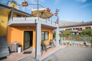 una casa gialla con balcone e panca di La Casa Del Grillo 2 ad Aosta