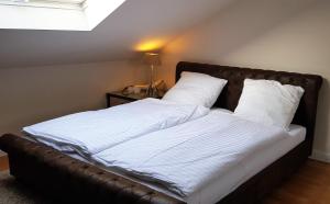 ein großes Bett mit weißer Bettwäsche und Kissen in der Unterkunft OLD OAK in Meerbusch