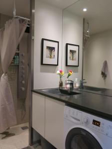 a bathroom with a washing machine and a sink at ApartmentInCopenhagen Apartment 427 in Copenhagen