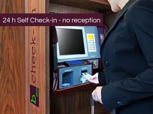 a person in a suit standing in front of a cash register at b-smart hotel Bendern in Bendern