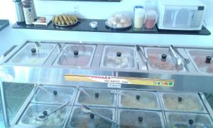 POUSADA OLÍMPIA في ماسيو: خزانة عرض في متجر مع بعض المواد الغذائية