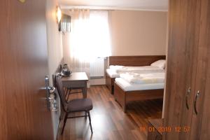 ein Schlafzimmer mit Bett, Schreibtisch und Fenster in der Unterkunft Hotelik Karter in Warschau
