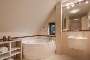 a bathroom with a large tub and a sink at Willa Rybaczówka z ogrodem in Puck +25 photos