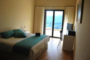 a hotel room with a bed and a large window at Buil & Gine Wine Hotel in Gratallops
