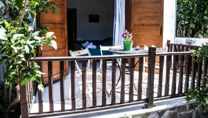 a wooden railing on a porch with a table at Iliahtides in Kala Nera