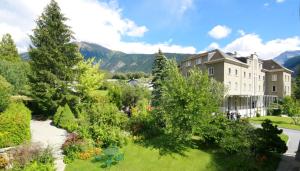 einen Garten vor einem großen Gebäude in der Unterkunft Hotel Haus Schönstatt contactless-Check-In in Brig