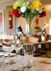 a table with wine glasses and a vase of flowers at Beachcombers Hotel in Saint Helier Jersey
