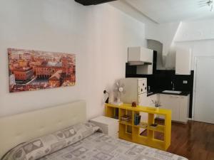 ボローニャにあるResidenza Porta Maggioreの小さなお部屋で、ベッド1台、黄色いテーブルが備わります。