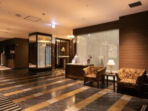 a lobby with two chairs and a desk in a building at APA Hotel Himeji-Eki-Kita in Himeji