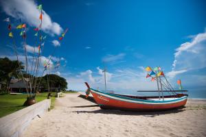 Un barco en la playa con banderas. en Fisherman's Resort Haad Chao Samran, en Haad Chao Samran