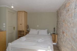 a bedroom with a white bed with towels on it at Ev Zin Basilicum in Leonidion