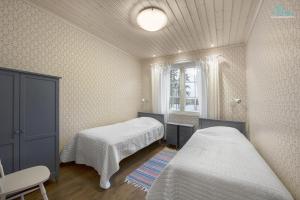 1 dormitorio con 2 camas y ventana en Huvilaranta Villas, en Isojärvi