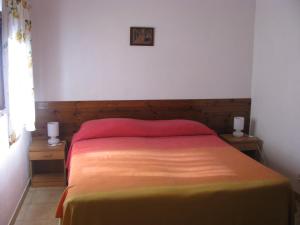1 dormitorio con 1 cama y 2 mesitas de noche con 2 lámparas en Montecaminetto, en Sacrofano