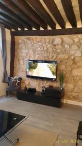 un soggiorno con TV a schermo piatto su un muro di pietra di Appartement St Martin a Parigi