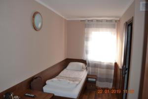 ein kleines Zimmer mit einem Bett und einem Fenster in der Unterkunft Hotelik Karter in Warschau
