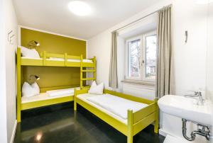 Zimmer mit 2 Etagenbetten und einem Waschbecken in der Unterkunft Jugendherberge Lenggries in Lenggries