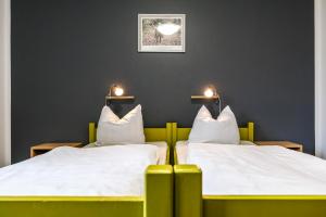 twee bedden in een kamer met verlichting aan de muur bij Jugendherberge Lenggries in Lenggries