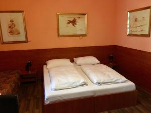 two beds in a room with white walls at Pension Madara in Vienna