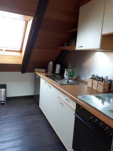 a kitchen with white cabinets and a sink and a window at Ferienwohnung Ruhenest in Willingen