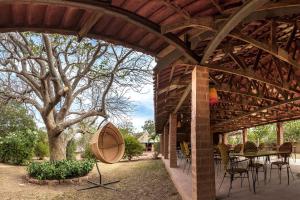 a wooden pavilion with a table and a tree at Sougri Doogo in Loumbila