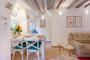 - un salon avec une table, des chaises et un canapé dans l'établissement Ca' Marcello - BIENNALE, à Venise